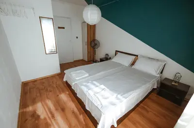 a bedroom with a white bed and a green wall at 2BDR Yavorov apartment in Sofia