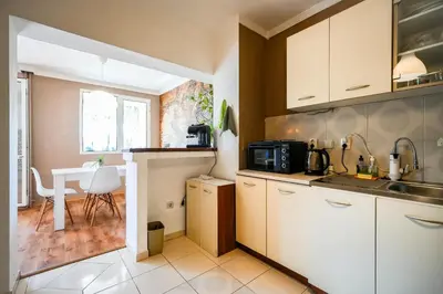 a kitchen with a sink and a table with a microwave at 2BDR Yavorov apartment in Sofia
