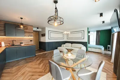 a kitchen and living room with a glass table and chairs at Уютно Студио Verde Suites 33 in Blagoevgrad