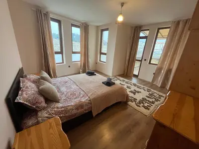 a bedroom with a large bed with windows at BELLA VISTA Holiday Home 24h check in in Sandanski