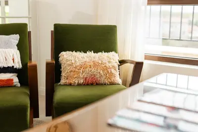 a green chair with a pillow on it next to a window at 21 Villa Vitosha Hills View in Hisarya