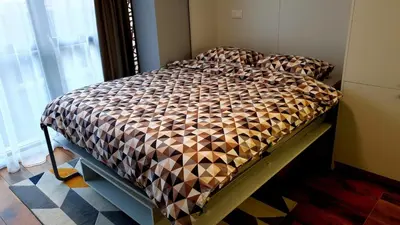 a bed with a comforter on it in a bedroom at Smart Studio in the heart of Sofia in Sofia