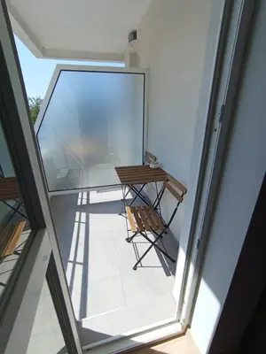 a balcony with a wooden table and a chair at Уютно Студио Verde Suites 07 in Blagoevgrad