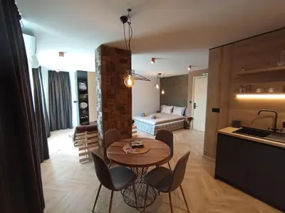 a kitchen and a living room with a table and chairs at Уютно Студио Verde Suites 07 in Blagoevgrad