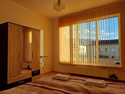 a bedroom with a large window with towels on a bed at Slavveykovs Apartment in Sofia