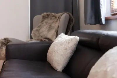 a brown leather couch with a pillow on it at 'Chamonix' in Bansko - 1 bedroom - SKI IN&OUT - Free spa in Bansko