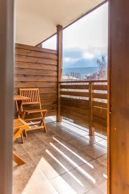 a balcony with a chair and a view of the ocean at 'Chamonix' in Bansko - 1 bedroom - SKI IN&OUT - Free spa in Bansko