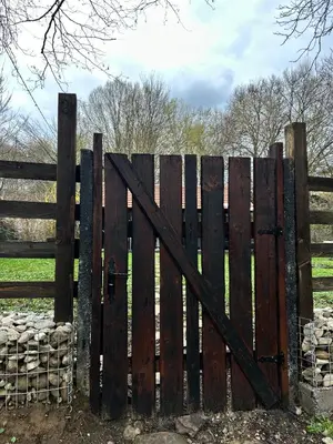 a wooden gate in front of a fence at VILLA INBAR - Village house on the river in Boykovets