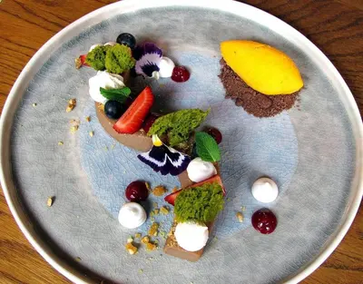 a plate of food with vegetables and fruit on it at Central Springs Apartment in Sofia