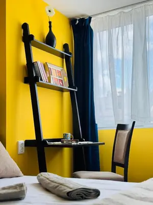 a bedroom with a yellow wall with a shelf and a bed at Central Springs Apartment in Sofia