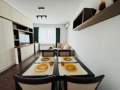 a dining room with a table and a living room at Central Springs Apartment in Sofia