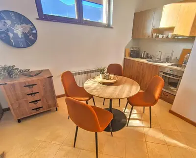 a kitchen with a table and chairs in a kitchen at Studio DeLuxe King with mountain view and spa rilski in Bansko