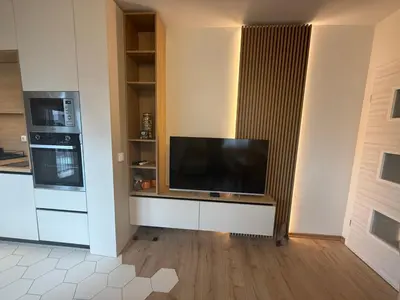 a living room with a large television on a wall at Koko's Cozy Apartment - free Garage Netflix and Balcony in Sofia