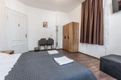 a bedroom with a bed and two chairs in it at Vitoshka Inn in Sofia