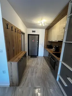 a kitchen with white cabinets and a wooden floor at Apartment Aria 4 in Velingrad