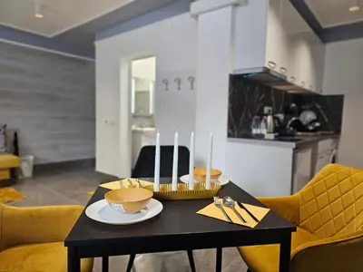 a dining room with a black table and yellow chairs at Continental studios 1 in Sofia