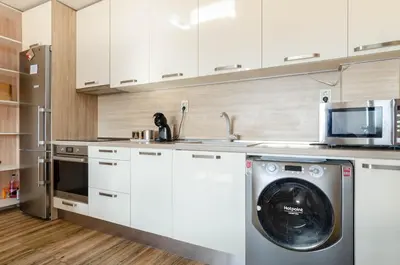 a kitchen with a washing machine and a microwave at Apart Center Nikola in Plovdiv