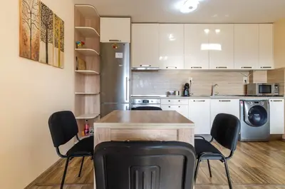 a kitchen with a table and chairs in a room at Apart Center Nikola in Plovdiv