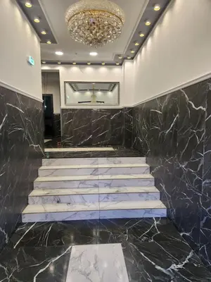 a lobby with marble steps and a chandelier at Continental studios 5 in Sofia