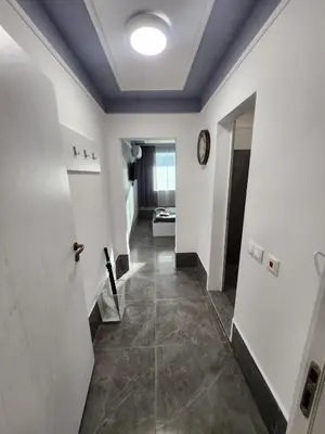 a hallway with white walls and a clock on the wall at Continental studios 5 in Sofia