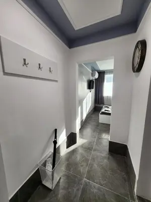 a hallway with white walls and a clock on the wall at Continental studios 5 in Sofia