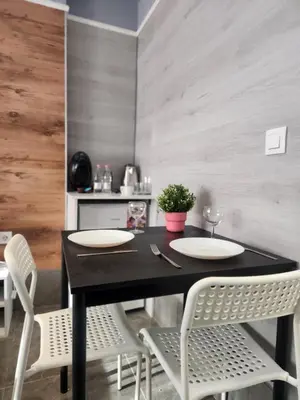 a dining room with a black table and white chairs at Continental studios 5 in Sofia