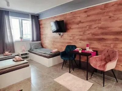 a room with two beds and a table and chairs at Continental studios 3 in Sofia