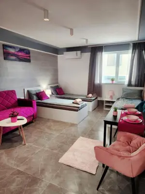a living room with a bed and pink furniture at Continental studios 3 in Sofia