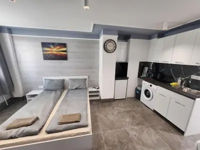 a small bedroom with a bed and a kitchen at Continental studios 2 in Sofia