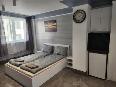 a bed in a room with a clock on the wall at Continental studios 2 in Sofia