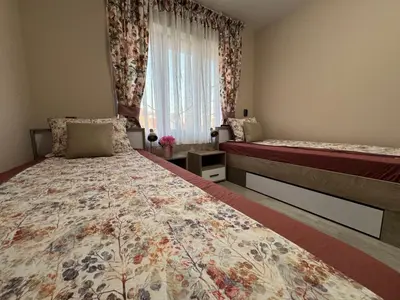 a bedroom with two beds and a window at Kamberovi house Kalofer Къща Камберови Калофер in Kalofer