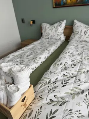 a bed with a white comforter and a drawer with towels at Kamberovi house Kalofer Къща Камберови Калофер in Kalofer