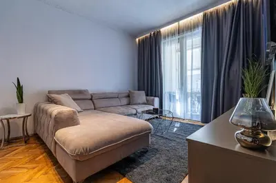 a living room with a couch and a large window at Grand Suborna Retreat in Sofia