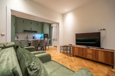 a living room with a couch and a flat screen tv at Elegant & Stylish 2-Bedroom Apartment in Sofia