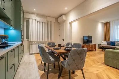 a kitchen and living room with a table and chairs at Elegant & Stylish 2-Bedroom Apartment in Sofia