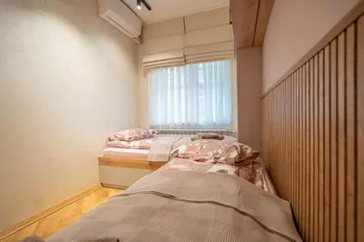 two beds in a room with a window at Elegant & Stylish 2-Bedroom Apartment in Sofia