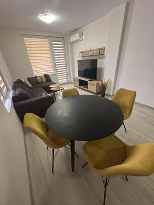 a living room with a table and yellow chairs at The Last Dollar in Sofia
