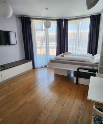 a large room with a bed and a television at Mallside Residences in Sofia