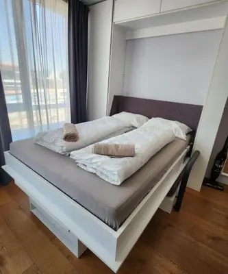 a bed with two pillows on it in a bedroom at Mallside Residences in Sofia