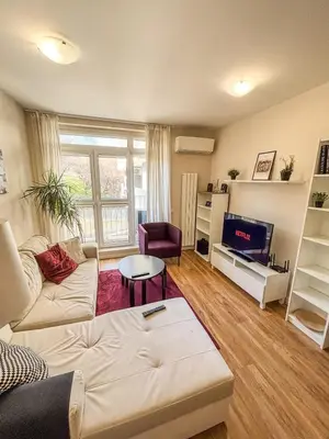 a living room with a couch and a tv at Scandi Suite Business & Leisure in Sofia