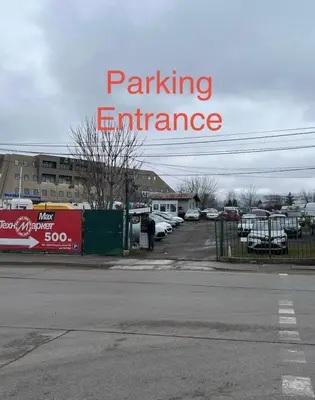 a parking entrance sign with cars parked in a parking lot at Scandi Suite Business & Leisure in Sofia