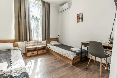 a small room with two beds and a desk at Vitoshka Inn - R3 in Sofia