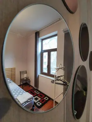 a mirror reflecting a room with a bed and a window at Hot Spot 2bdrm apartment 1 in Sofia