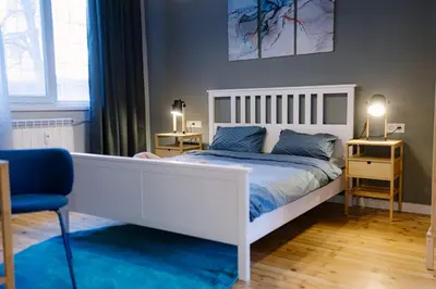 a bedroom with a white bed and a blue rug at 35 Seconds Away From the Main Street, Free Secured Parking in Sofia