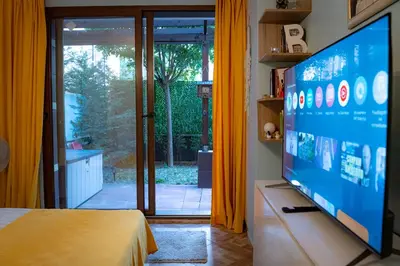 a bedroom with a flat screen tv and a bed at Claire Apartment with Garden in Sofia