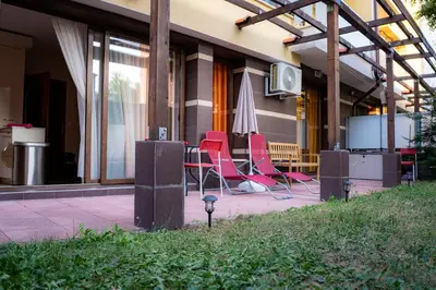 a group of chairs and an umbrella on a patio at Claire Apartment with Garden in Sofia