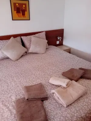 a bed with three pillows and towels on it at Belvedere Holiday Club Apartment 503 in Bansko