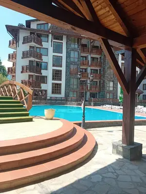 a swimming pool with stairs next to a building at Belvedere Holiday Club Apartment 503 in Bansko