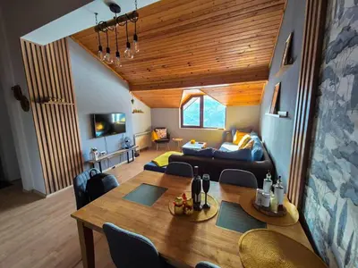 a living room with a table and a couch at Nordic Sunset Retreat in Pamporovo