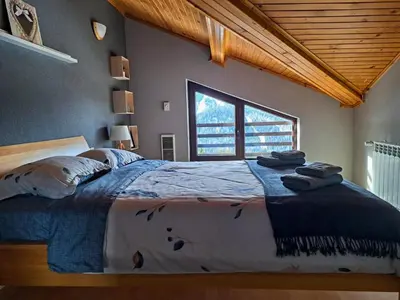 a bedroom with a large bed with a large window at Nordic Sunset Retreat in Pamporovo